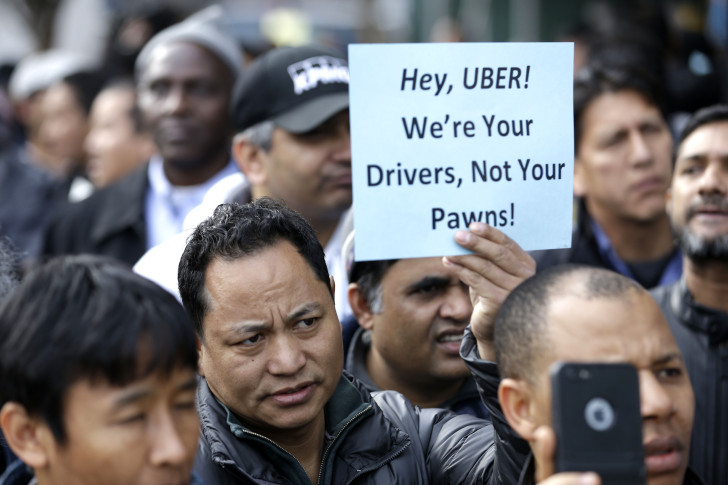 Uber司机上街抗议，手握标语“Uber，我们是你的司机，不是你的卒子”。图片来源AP/Seth Wenig
