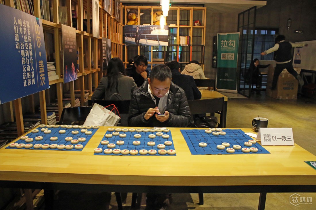 三个棋盘上，他摆了一个残局，还在牌子上附上了自己微信的二维码。他说，用这样的方式，也是因为自己很喜欢下象棋。