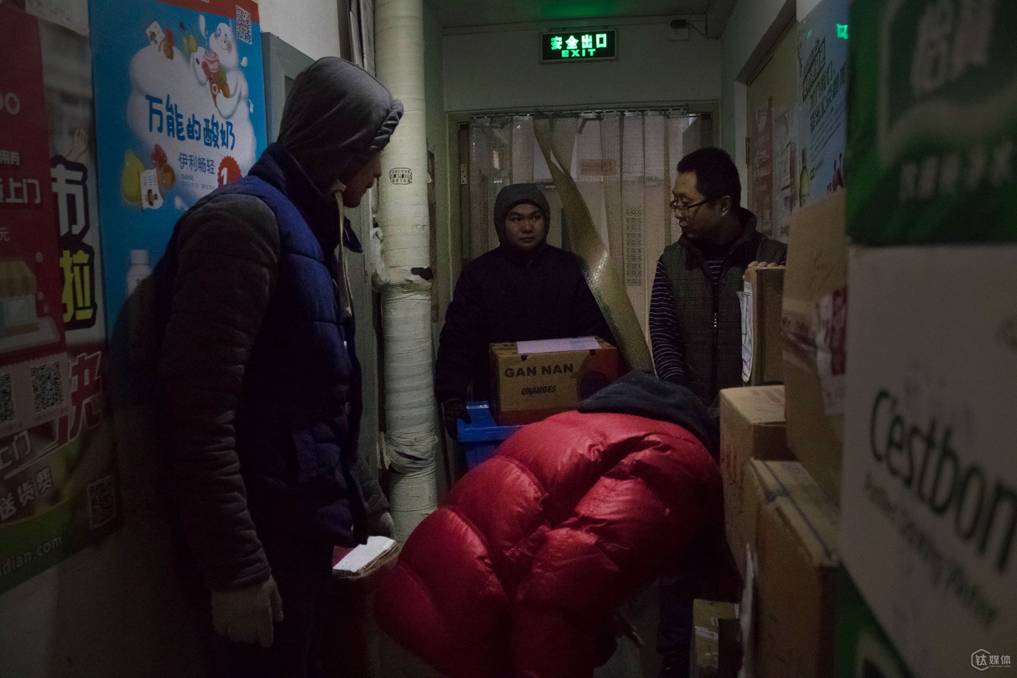 11点30分，几个快递员同时挤在了店门外的过道。这家小店每天最多时有将近20家快递公司的快递员过来送包裹，由于地方不够，大家会把一些纸箱的大件放在过道。