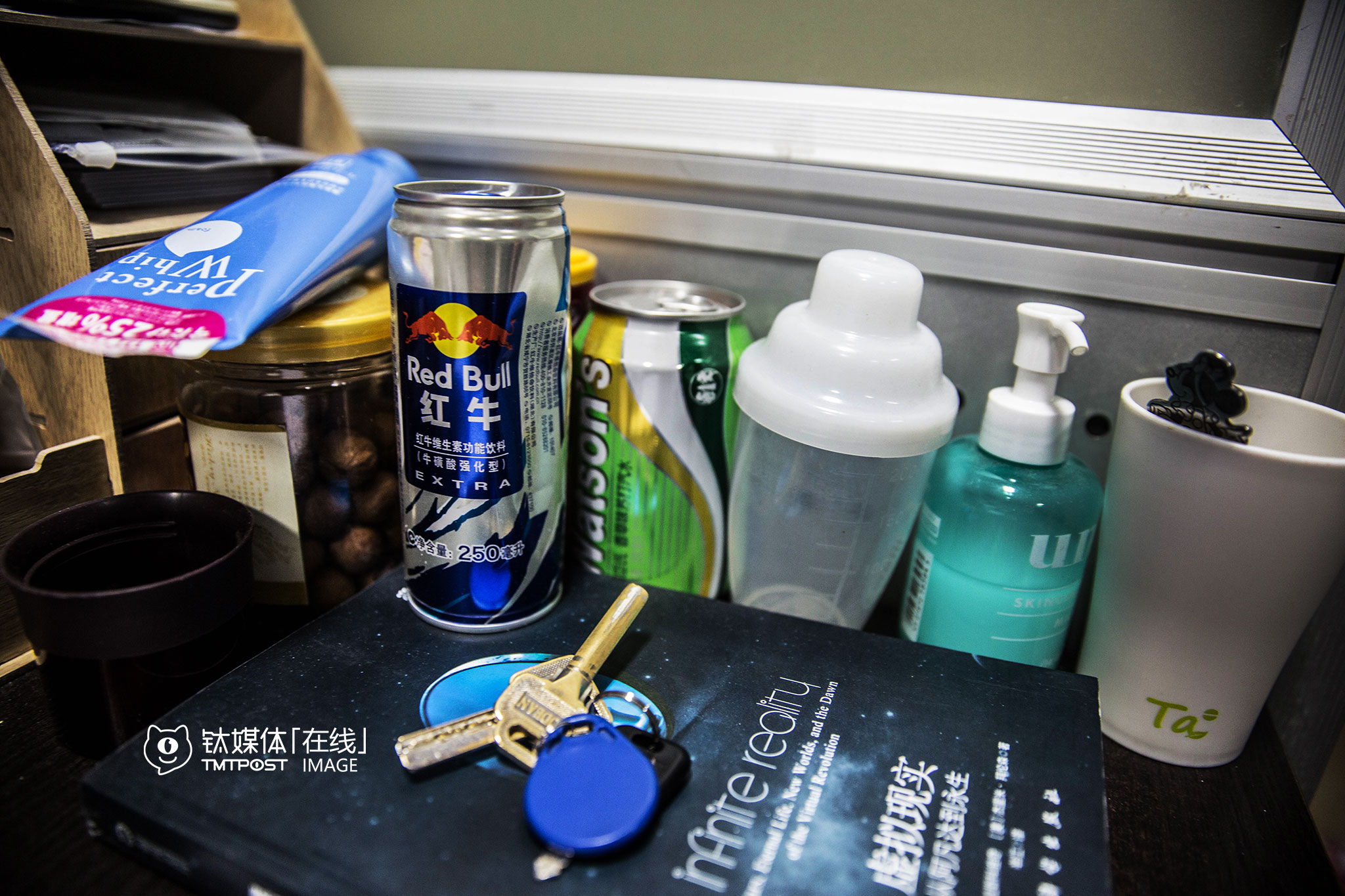 由于团队人员变动，加班成了他最近的常态。桌上的红牛和洗面奶，都是用来提神的。