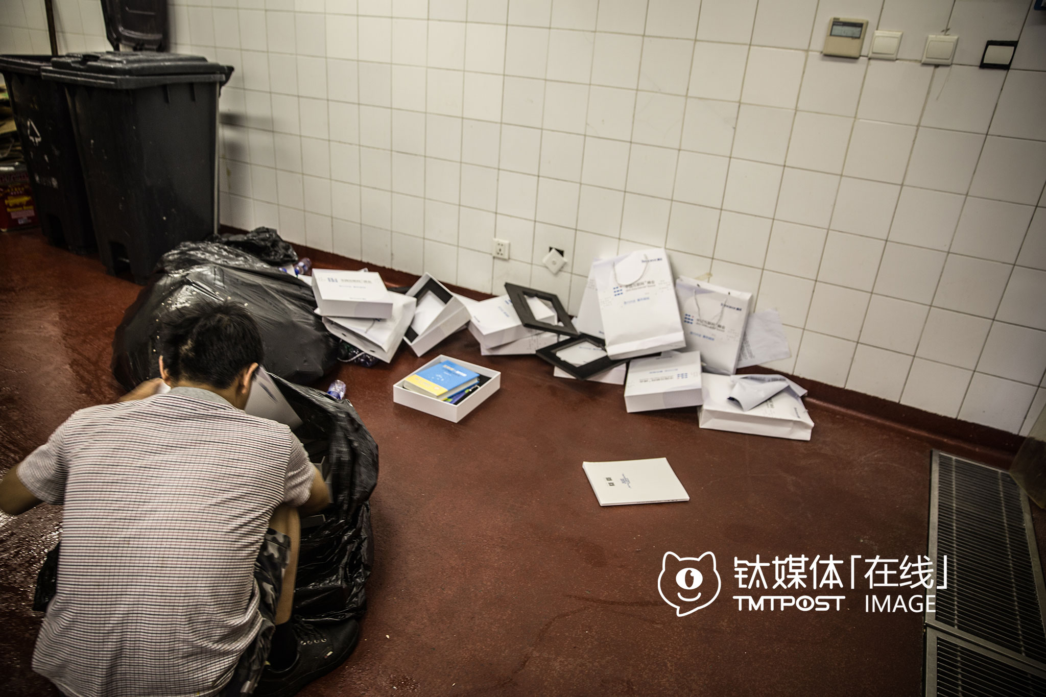 北京，国贸三期B2的垃圾房，一个会议结束后，保洁从现场收来了与会者留下的大量纸袋、礼物，“里面有书，但我也看不懂，没用，待会就有回收废品的来拉”。