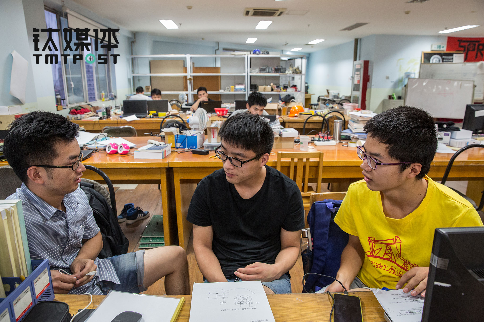 队员汪文松（中）和队友讨论新一届Robocon的规则，汪文松今年大四，目前正在找工作，他理想中的公司是大疆。而大疆作为Robomasters的赞助商，也将这一比赛作为发掘和培养人才的重要平台。