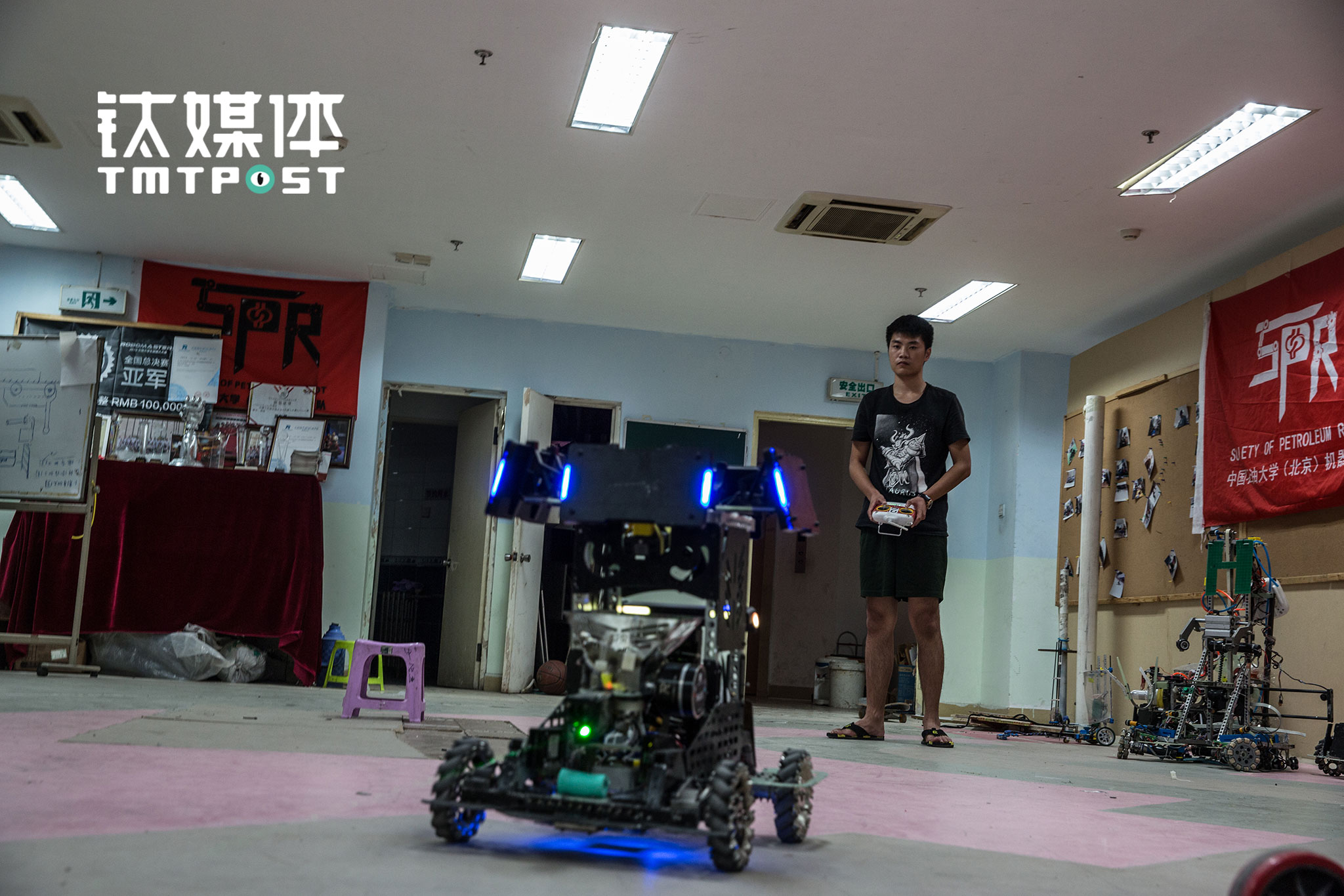 SPR战队电控组成员潘学亮在调试“英雄”战车。除了上课，潘学亮几乎把时间都花在了SPR的实验室中。“英雄”战车的攻击力和生命值都是最强的，是一个机器人战队的主攻，所以潘学亮的工作“至关重要”。