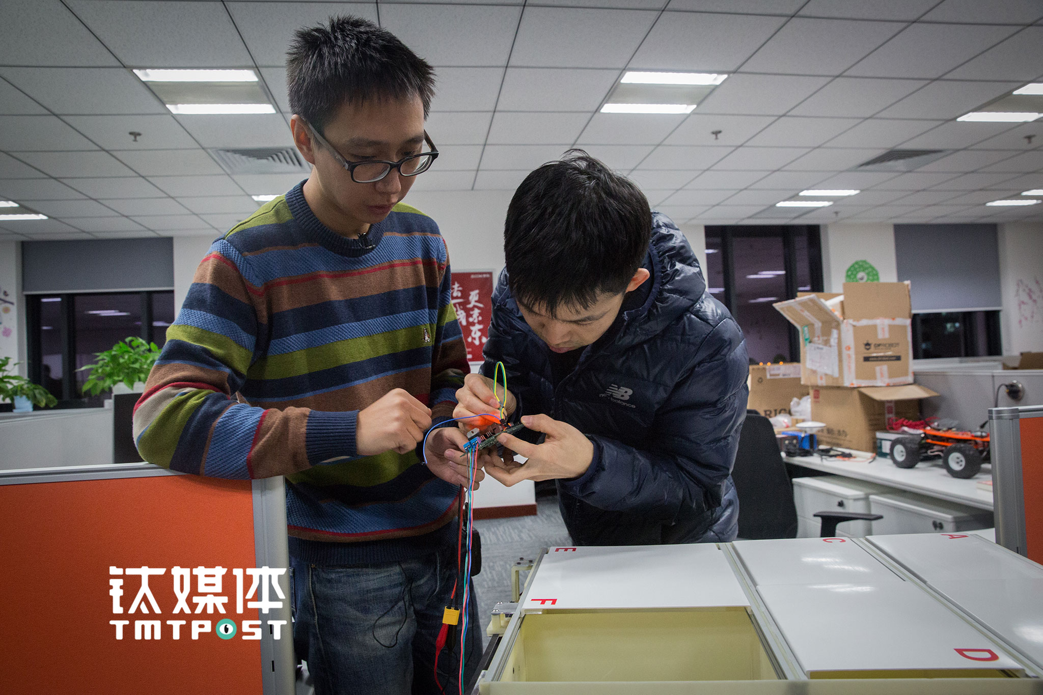 张潮和同事在进行无人车货箱箱门的测试。京东无人车试运营，将主要选择在园区及封闭道路进行，“有一小部分开放道路的非机动车道，是从快递站点到园区门口”，张潮介绍，中期目标是希望小车能覆盖更多地方，甚至进入居民楼上下电梯，“远期来看，无人车要成为完全自动化的快递员”。