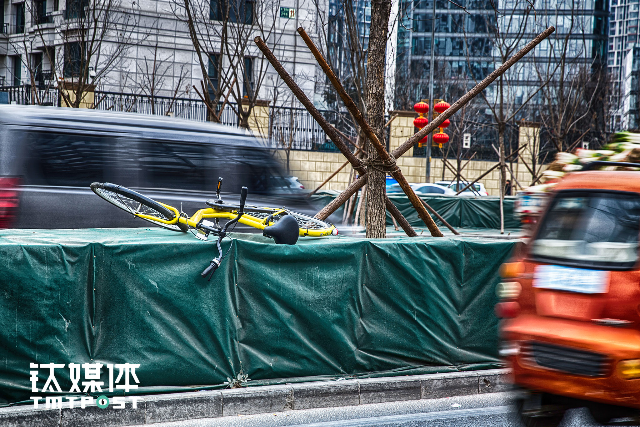 来广营地铁站外，一辆被倒放在道路绿化带的ofo。