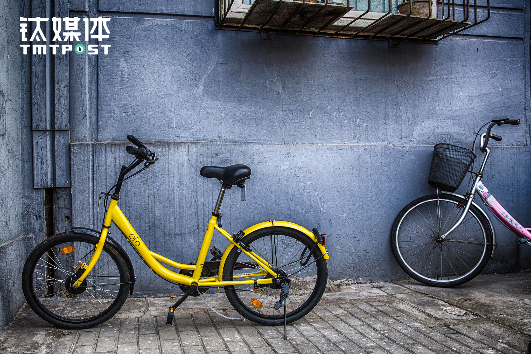 南二环某小区外，一辆被损坏的ofo停在居民楼下，这辆车的车把被拧到反转过来，链条掉了，车后轮还被加上了一把锁。