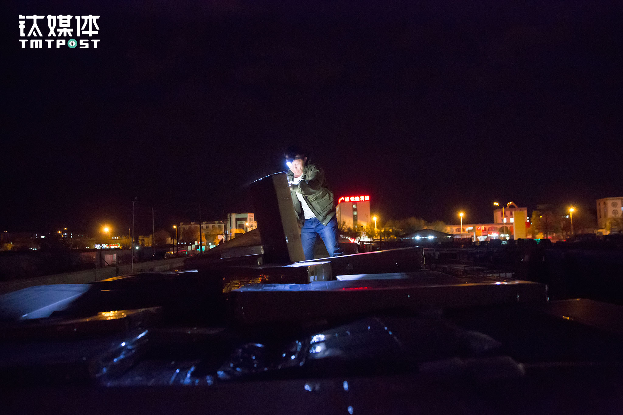 叉车装完大件，还有一些小件在顶上，金强又爬上车顶开始清点。