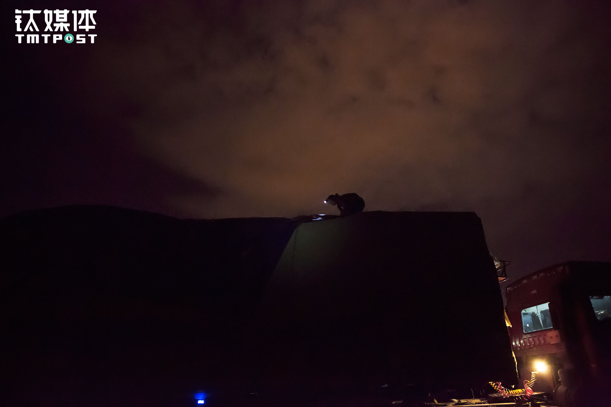 货仓盖了三层篷布，拆完绳子，金强要到车顶把三层布依次掀开。