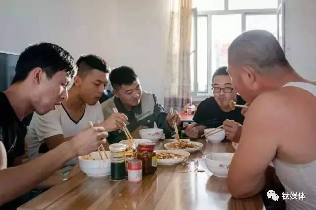 工人们在矿池边的饭厅里吃晚饭