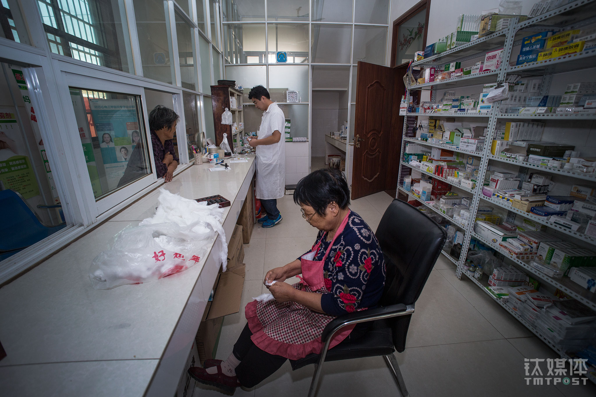 师进峰在给人拿药，他的母亲（右）在一旁整理药棉。老人从18岁开始在这个村当&ldquo;赤脚医生&rdquo;，&ldquo;经她手接生的孩子都有好几百&rdquo;。母亲当医生的年月，师进峰并不喜欢医生这个行当，因为他看到母亲每天都非常忙。师进峰上中学时，父亲被查出肝脏问题，病了很多年直到去世，这给他极大震撼，他深刻体会到病患家属的不易，认识到医生的重要性，才立志学医，&ldquo;后来毕业，我妈老了，村里的卫生室眼看没人来接班，我既然是学医，又要照顾家，就干脆回来接着干卫生室了。&rdquo;师进峰告诉钛媒体《在线》。