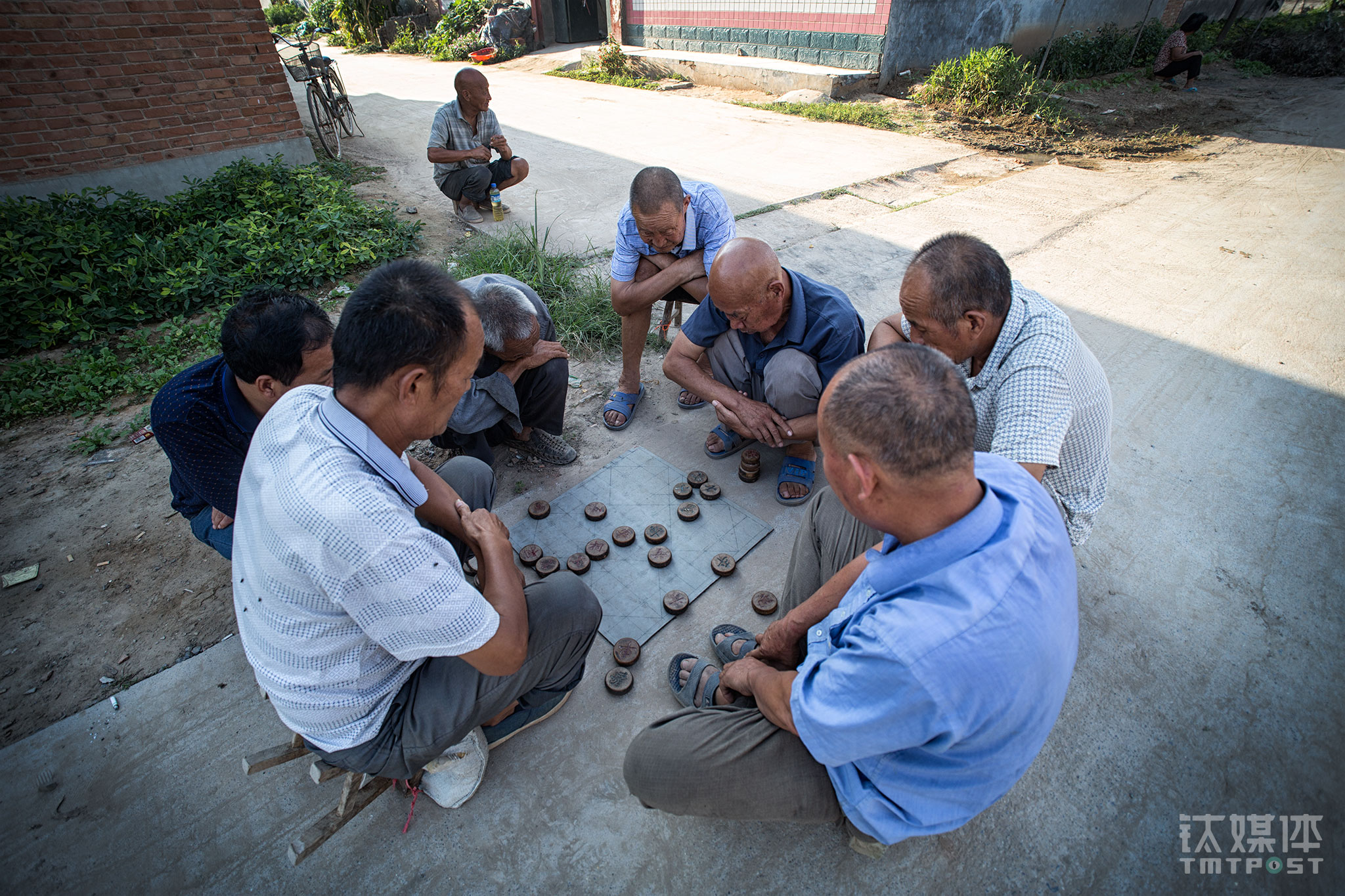 卫生所附近，几位老人在路边下棋。村子里最多出现的是老人和孩子，青壮年大都外出务工，像师进峰这样一直留在这里的年轻人几乎没有。