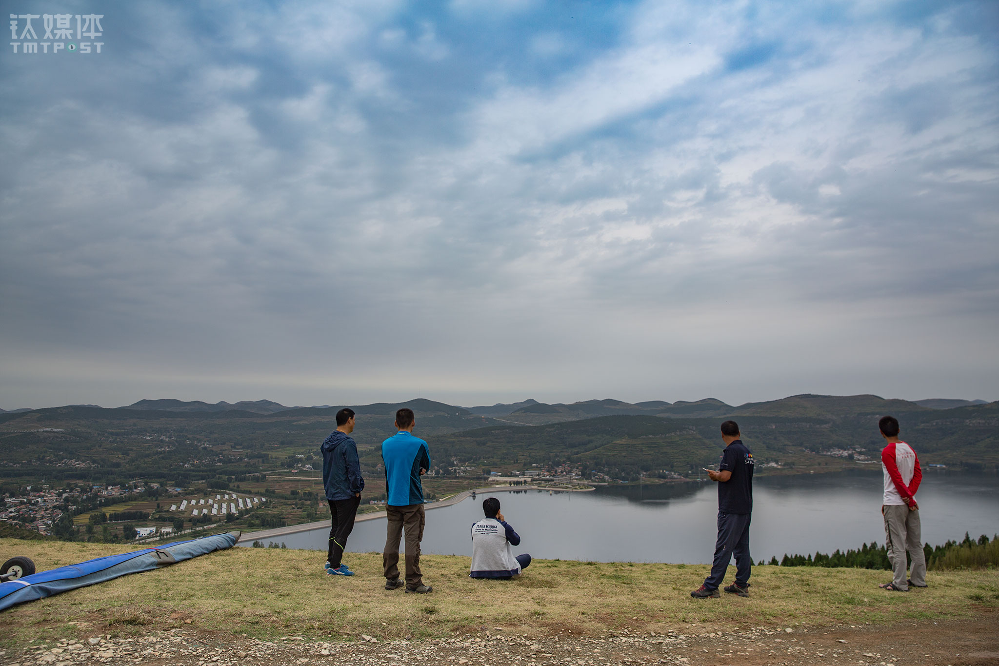 营地的高山起飞场海拔220米，如果风向、气流合适，滑翔伞飞手从这里起飞后可以飞行2~3个小时，最高可盘旋至2000米高度。但这一类航空运动需要&ldquo;看天吃饭&rdquo;，要有适合的自然条件才能起飞。远道而来的飞手们在中体教练的陪同下来到起飞地点，却发现风向有变，大家只好原地等待小气候的改变。