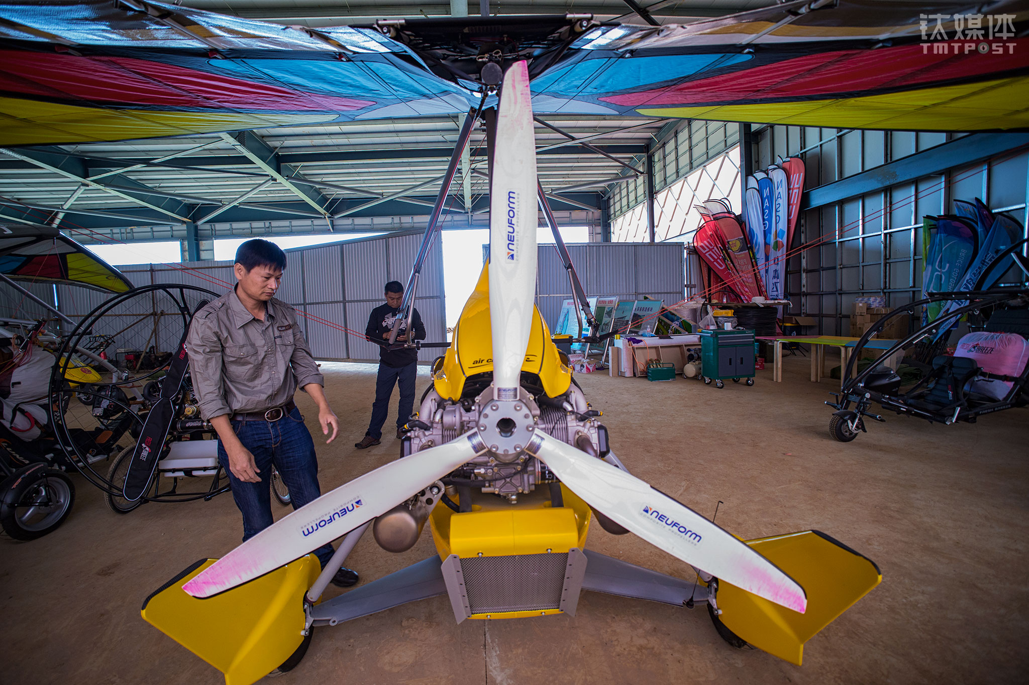 中体飞行机师彭建平在对机库内的动力三角翼进行检查。彭建平曾是飞机制造厂的机师，在飞行行业从业20多年。这是一个痴迷发动机的人，作为营地机师，他主要工作是对飞行器进行维护，&ldquo;主要是发动机，按照发动机厂给的维护时间表严格进行维护&rdquo;，彭建平告诉钛媒体《在线》，飞行前后他都要对飞行器的细节进行监控，进行隐患排查。
