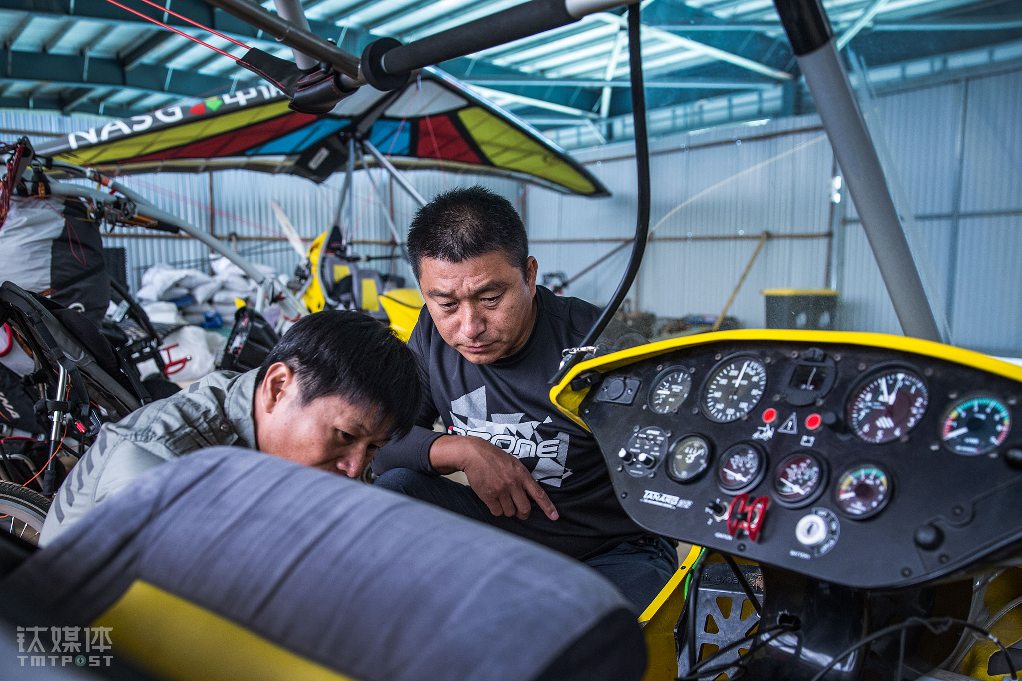 中体飞行教练范小伟（右）在察看一台动力三角翼的刹车。范小伟是一名&ldquo;老资格&rdquo;航空人，他从业30多年，曾参与多项飞行相关国家标准的起草和制定和各类国家级飞行比赛标准的指定。&ldquo;航空运动和冒险、刺激的关系不大，它需要详尽细致的计划，是一种厚积薄发，而不是头脑发热去冒险&rdquo;，范小伟看到这么多年国内这一运动的发展，&ldquo;国内刚刚开始走向秩序和规范，在建立良性发展的系统。航空运动这个市场一旦爆发，如果我们的准备和积累应付不了，就会引起很多问题。&rdquo;