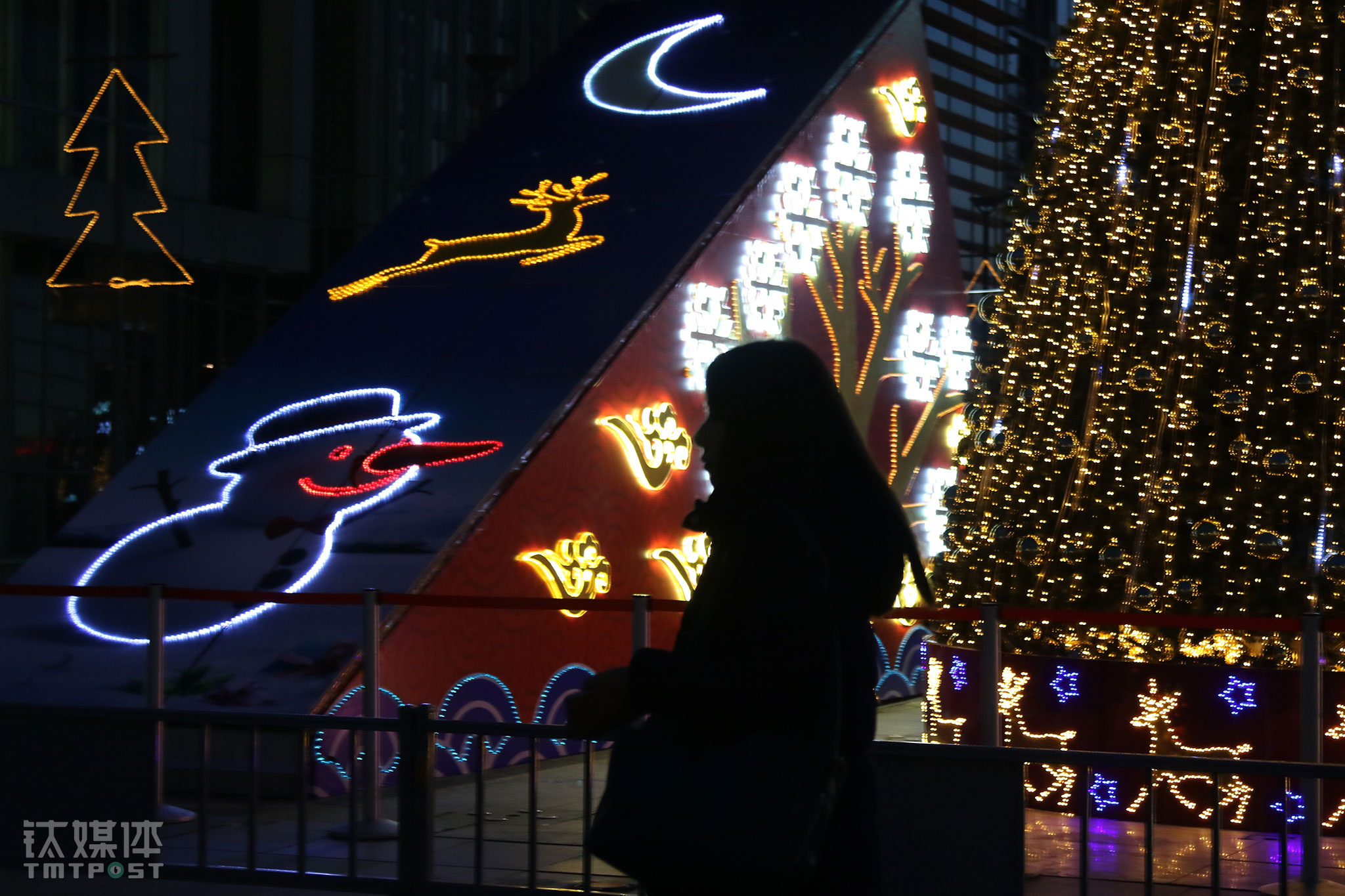 2015年圣诞节前夕，完成当天工作后，速记师任倩乐从一棵圣诞树旁经过。从2004年来到北京，她一直在做速记。每天穿梭在各个会场，在角落里安静第听着发言，打着字，对这个工作了十多年的城市，她说自己没有什么归属感。（一个速记师的故事）