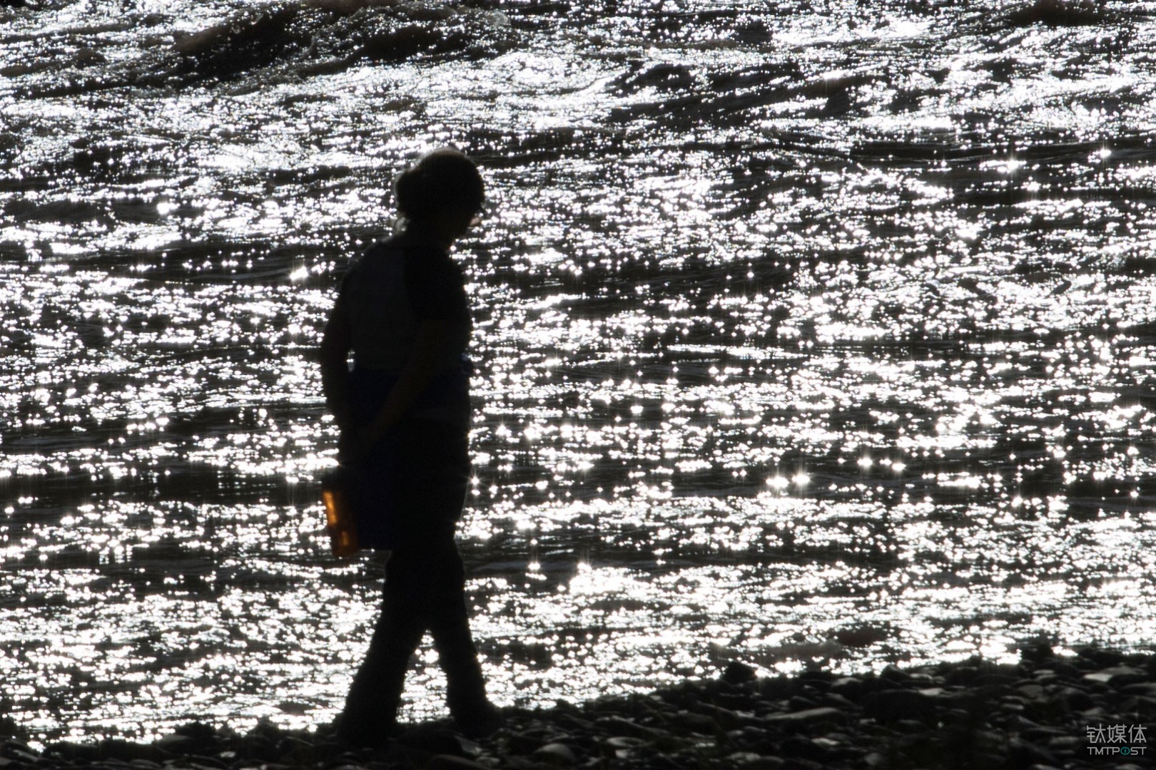 粼波微步。青海玉树杂多县，游客在澜沧江边散步。