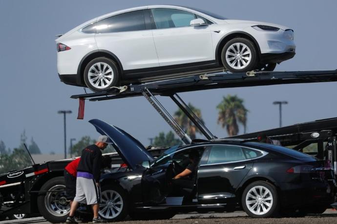 2018年8月24日，美国加利福尼亚州伯班克，新生产的特斯拉汽车被放到运输拖车上，那里停放了大量新生产的汽车