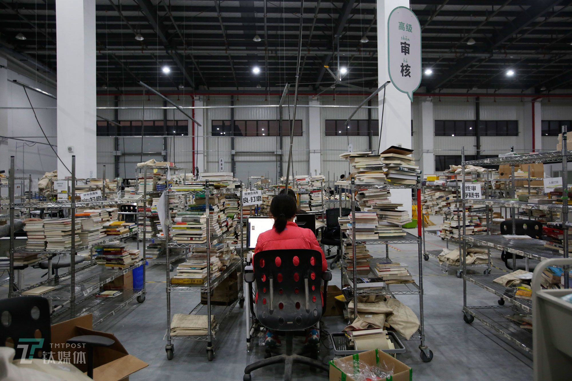 贴完抓码的书，就会进入审核环节。审核环节需要对书进行品相分级和正盗版鉴定。其中初、中级审核主要负责品相鉴定和下一步翻新流程分类，高级审核主要负责对初中级审核难以辨别的疑似盗版书进行鉴定。（陈拯 摄）