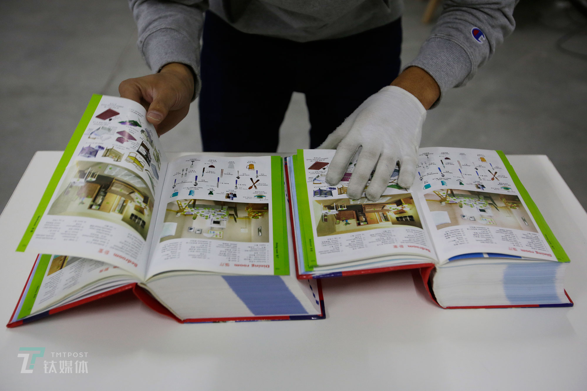 杨玉擎的同事在对两本词典做正盗版鉴定。他们总结了盗版书的五个通用特征：书的腰封印在封面上；外文书封底有中文书名或中文拼音；封案连着扉页，书没有前衬页和后衬页；直接印着&ldquo;XX全集&rdquo;字样或把套装书缩印成一本；平装绘本定价高于20元。（陈拯 摄）