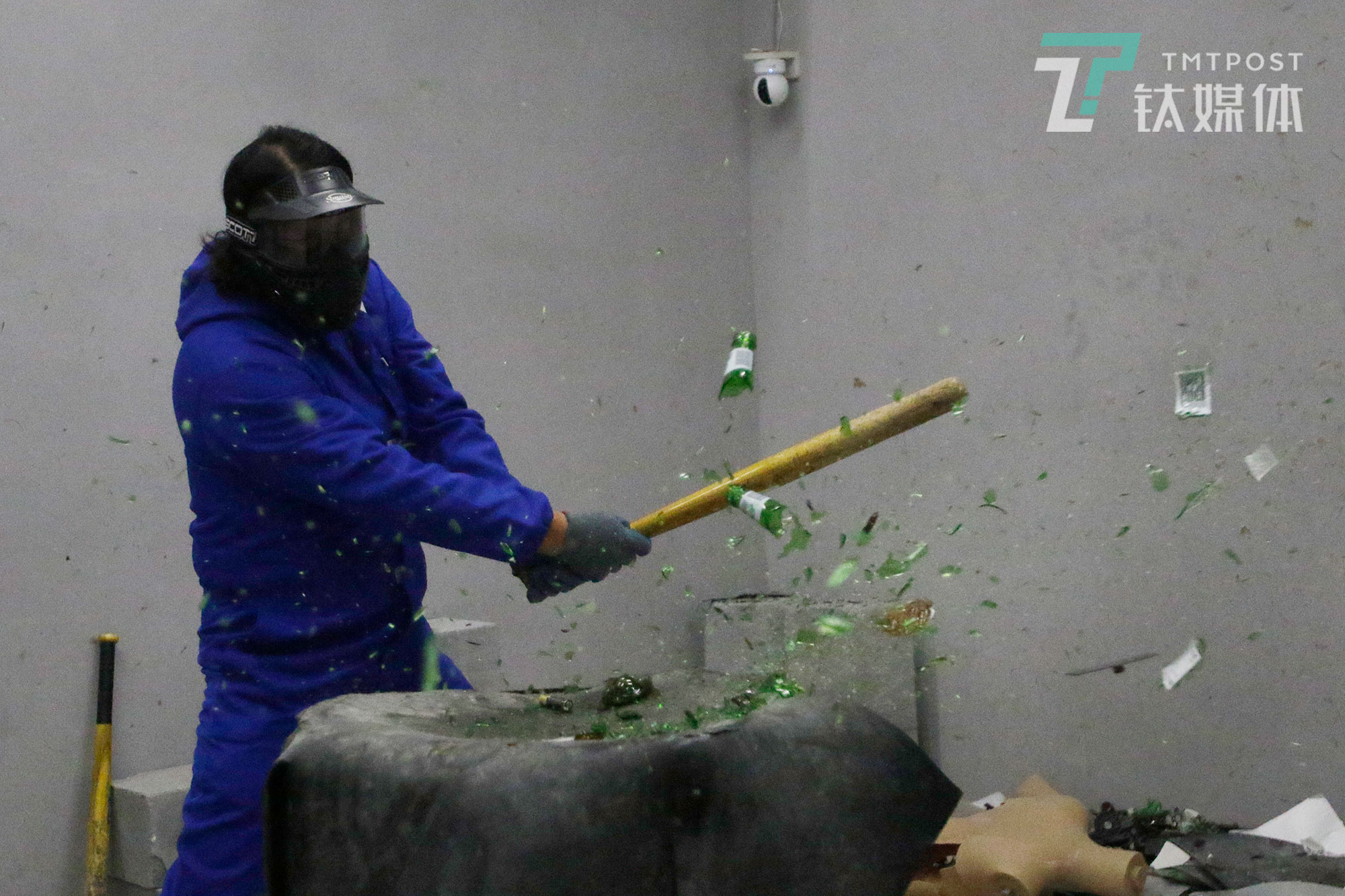 一名男顾客砸碎一个啤酒瓶子。发泄屋播放的音乐，加上瓶子破碎瞬间的快感，让挥棒的人大呼过瘾。