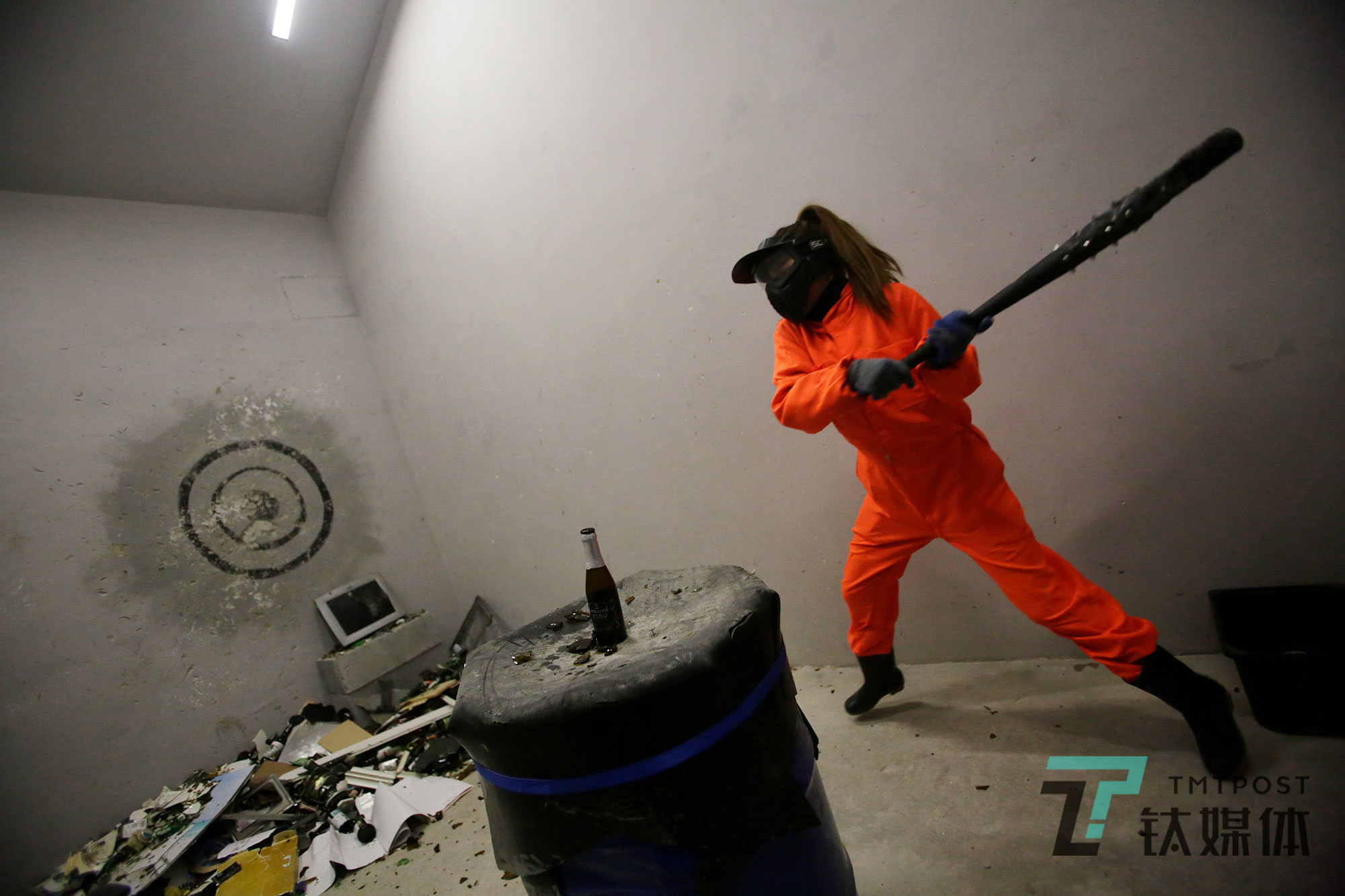 一名女顾客抡起棒球棍砸向酒瓶。