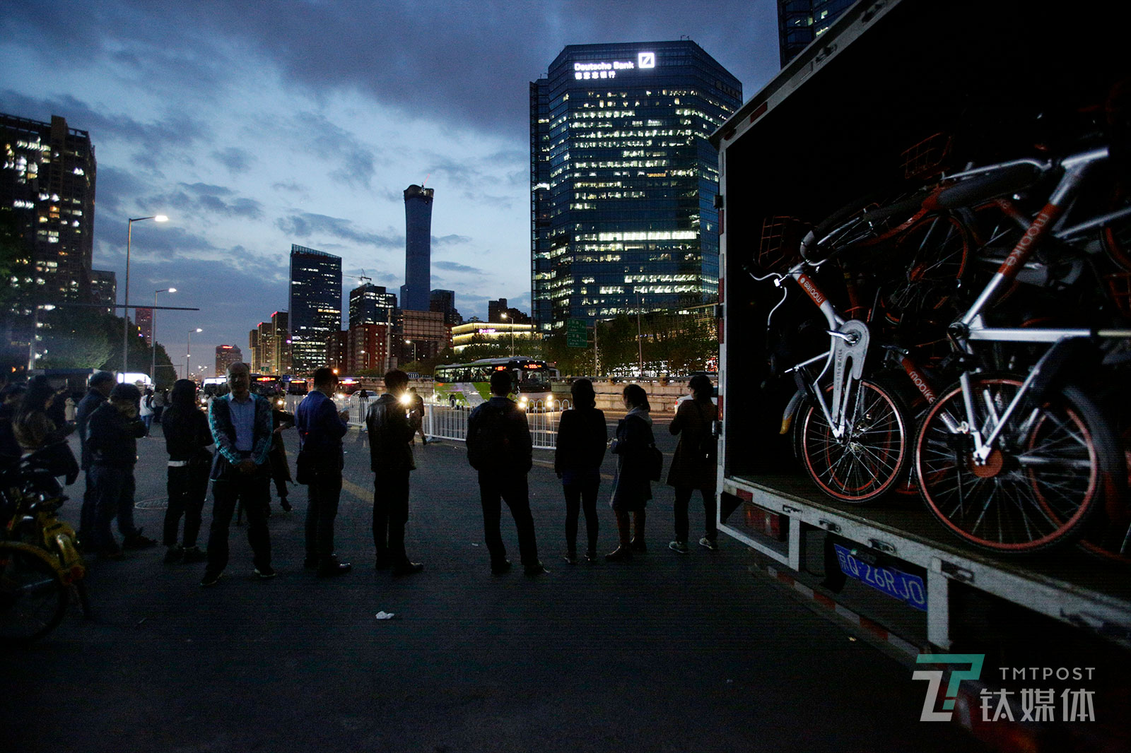 【归途】4月23日晚，北京CBD八王坟公交站，等待去往燕郊班车的上班族和即将被运走的摩拜单车。