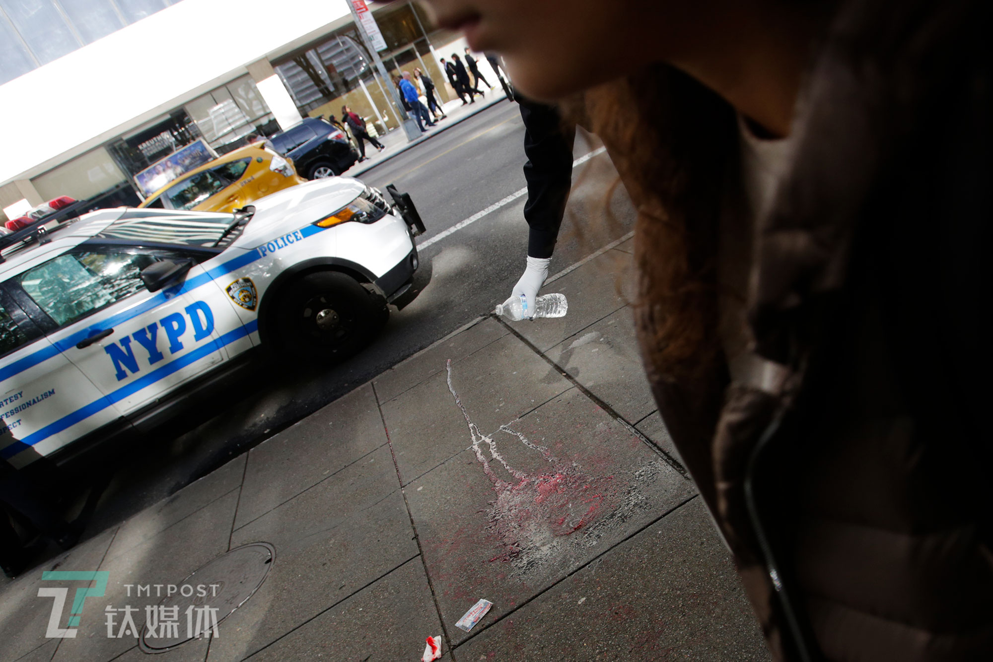 【NYPD】10月20日，美国纽约曼哈顿街头，一起持刀抢劫案现场，警察用矿泉水清洗伤者留在地面的血渍。