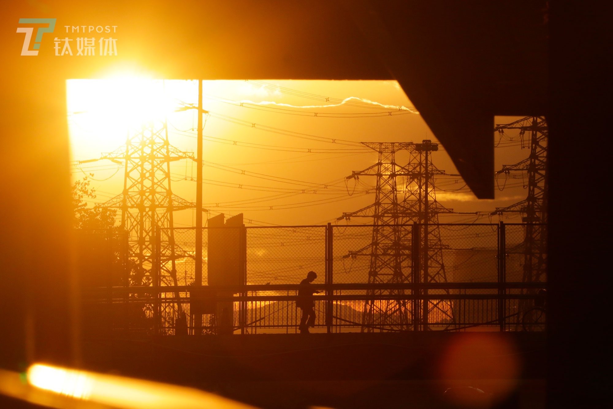 【东五环晚霞】9月29日，北京&ldquo;最美晚霞&rdquo;刷屏，从东五环传媒大学地铁站内望去，金黄的天空下，一位行人步行穿过京通快速路天桥。