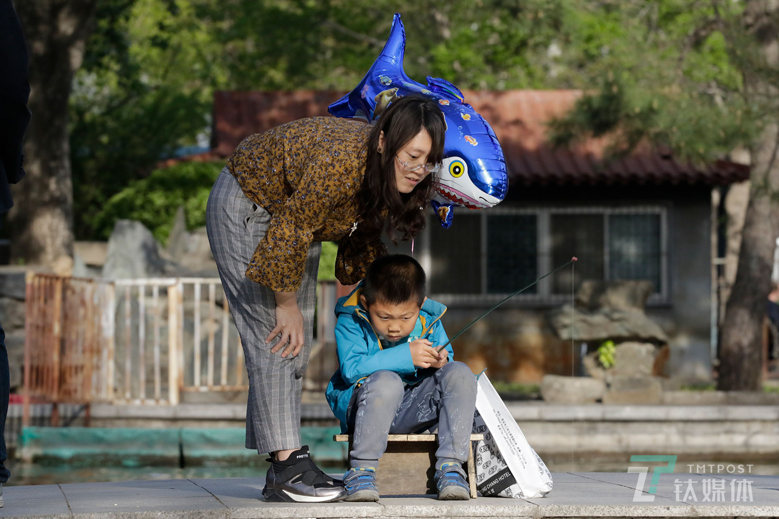 【钓鱼】4月15日，北京日坛公园，一位母亲陪孩子钓鱼。