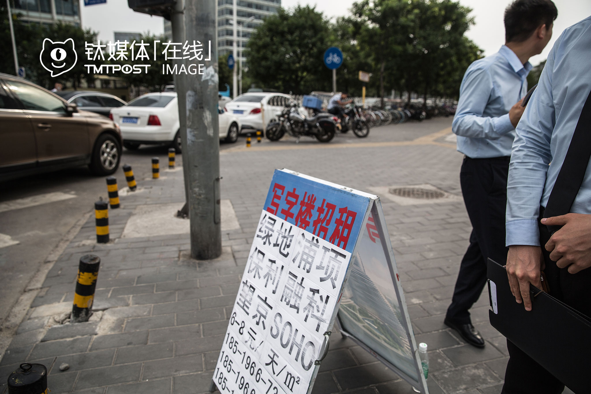 望京SOHO附近，写字楼中介在招揽生意。2014年建成并对外租售后，望京SOHO吸引了陌陌等一批互联网公司落户，2016年6月到7月，这里第一批租户两年租期合约陆续到期，离开和入驻的公司都在行动，这正是中介最活跃的时候。
