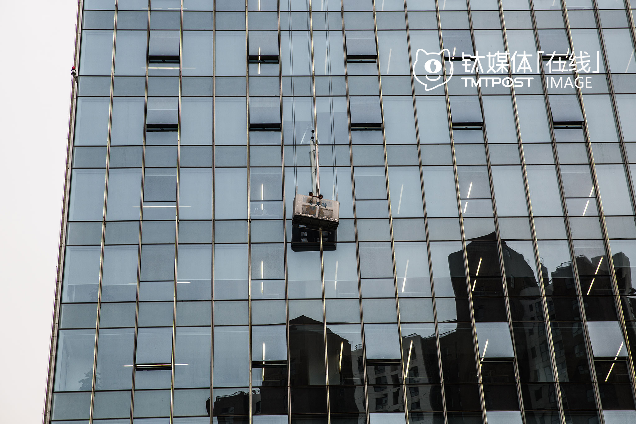 2016年7月14日，望京绿地中心，阿里巴巴北京总部，两名工人在进行玻璃幕墙清洁。这是阿里在杭州以外的地方所购置的第一栋办公楼，悬挂在150米高空的阿里标志，正在成为望京的新地标。而此时，距离马云第一次带着团队到北京寻找机会，已经过去19年。