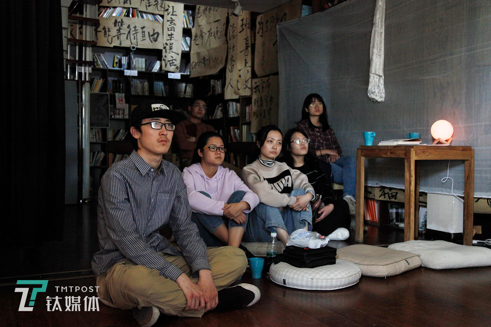 4月14日，参展的观众在看社畜博物馆剧场放映的日本过劳死案例采访视频。有的观众表示“看完视频觉得很压抑却又现实，会联想到自己的工作状态，觉得可怕。”