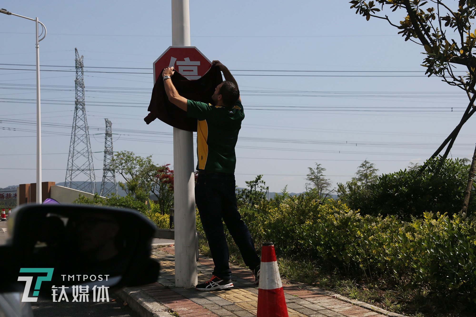 2D队竞争对手 “2EASY”队的道路训练中，队队员用衣物遮挡停车标识来检测系统识别效果。