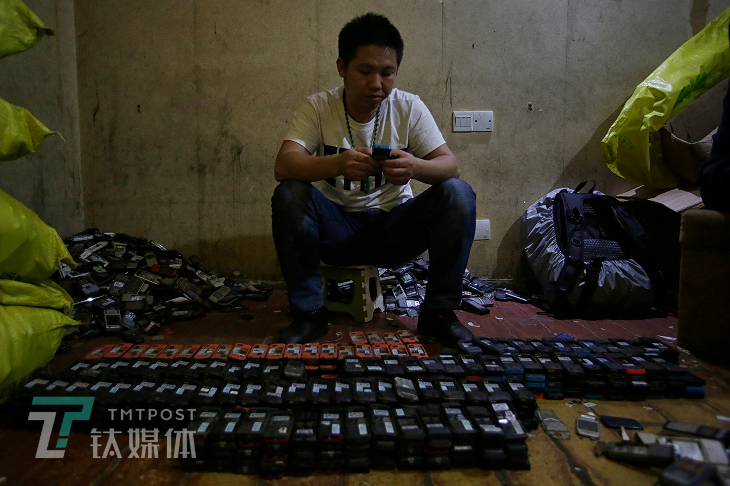 2月20日，深圳华强北附近某废旧手机回收市场，一名回收商在清点一批诺基亚功能机。这些手机中的一部分将被翻新转卖到非洲，另一部分将被送往贵屿等地用于提炼黄金。