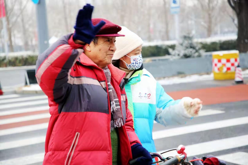 张秋红（右）扶老人过马路