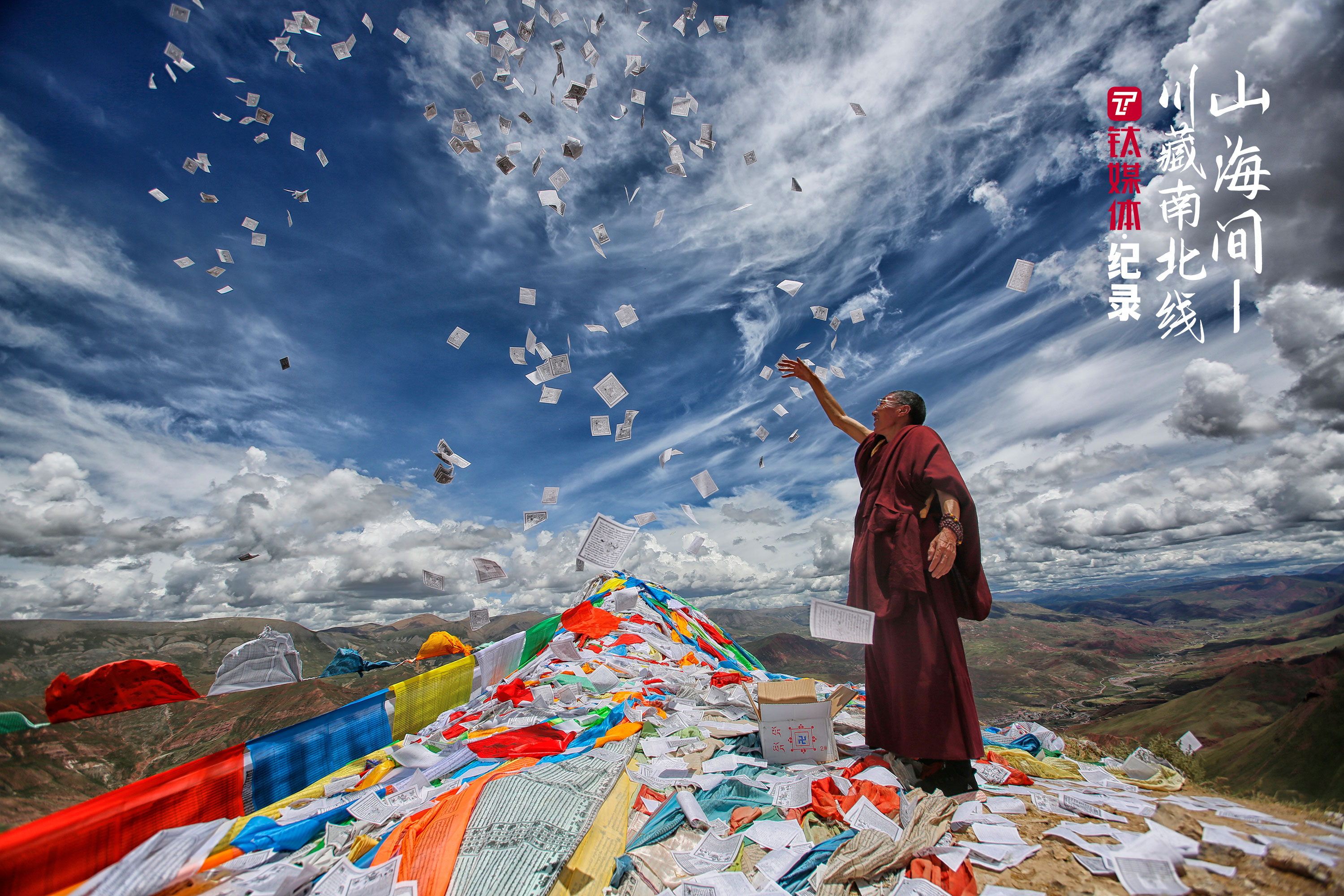孜珠山顶，一位僧人在撒龙达祈福。龙达是一种可降解的小纸片，上面印满了经文，也被称为乘风飞腾的骏马，简称&ldquo;风马&rdquo;。