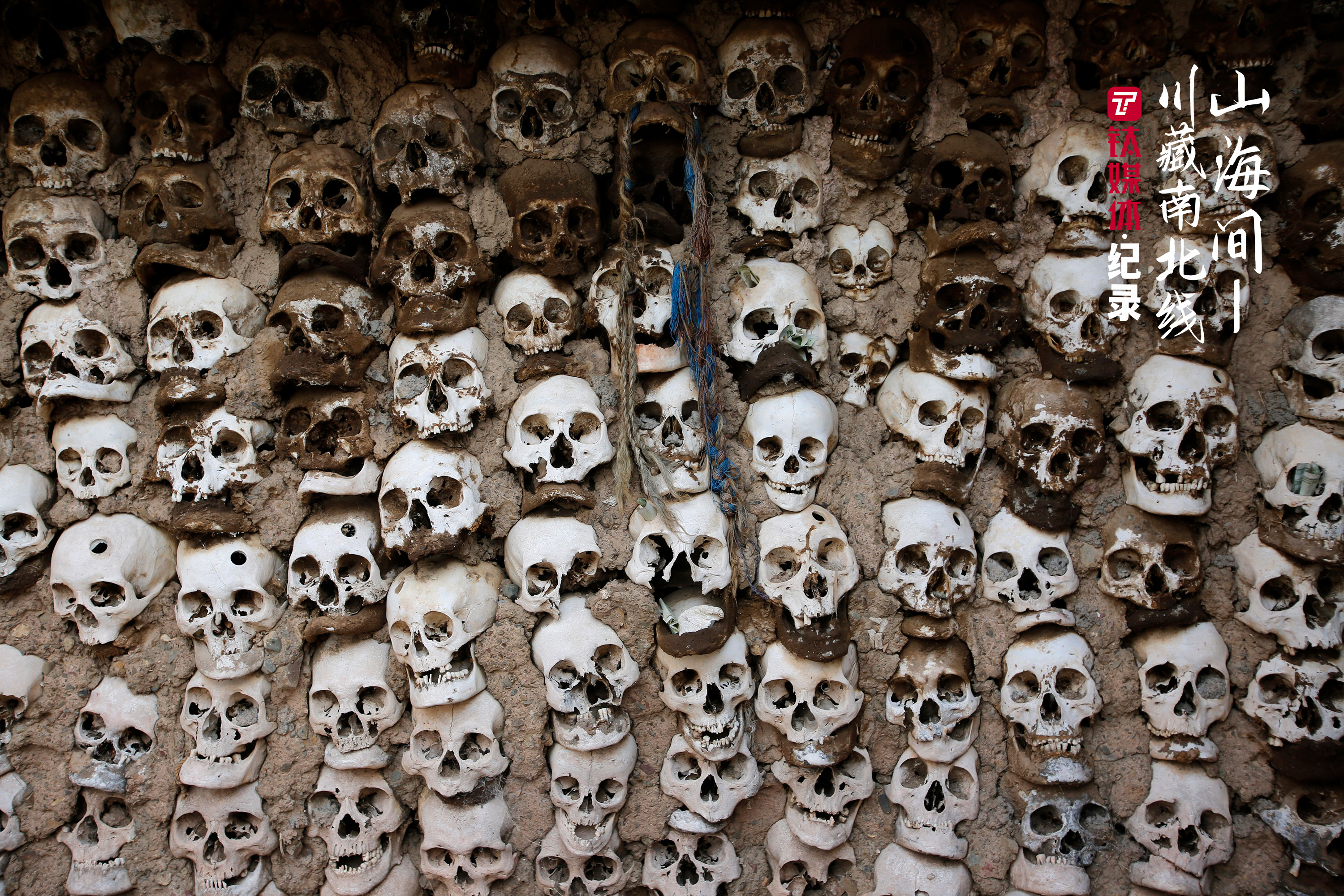 天葬台的墙壁上，嵌入泥土的骷髅头。讲解人员介绍，一些头骨的额头上的小孔，是被天葬师取走头骨用去制作嘎巴拉佛珠。