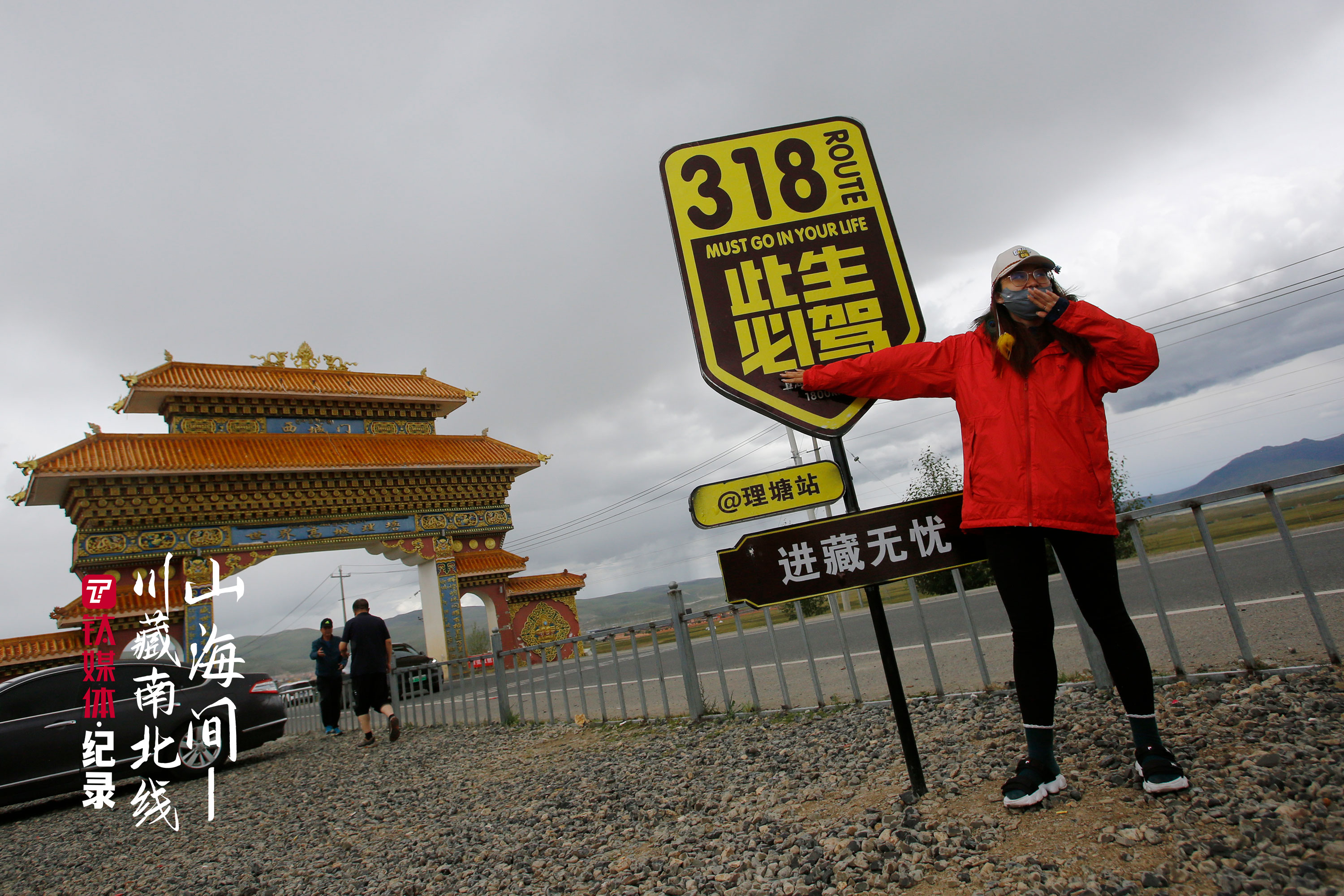 理塘城西城门外，拍照留念的游客。