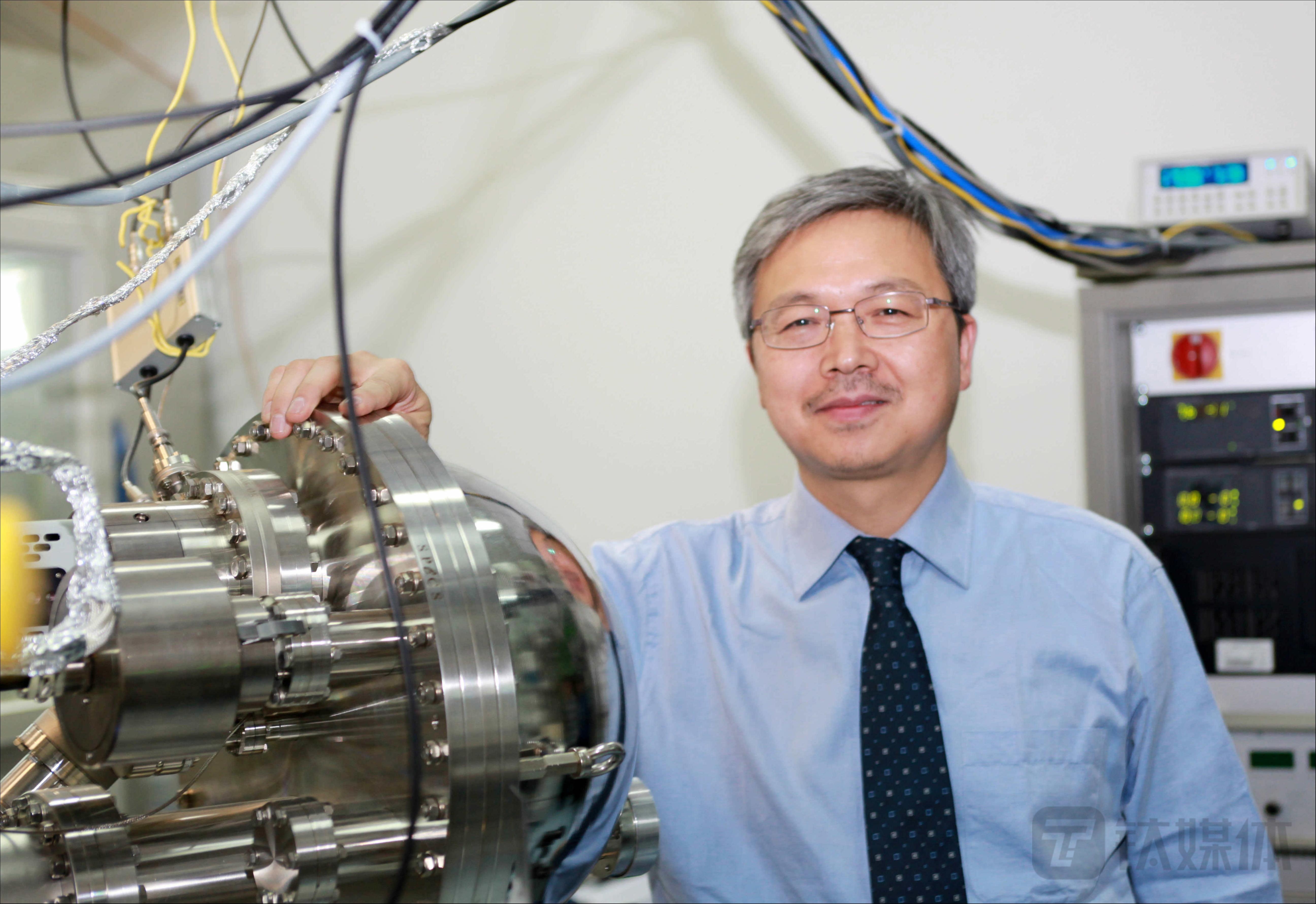 楊學(xué)明在交叉分子束儀器旁邊（來源：中科院大連化物所）