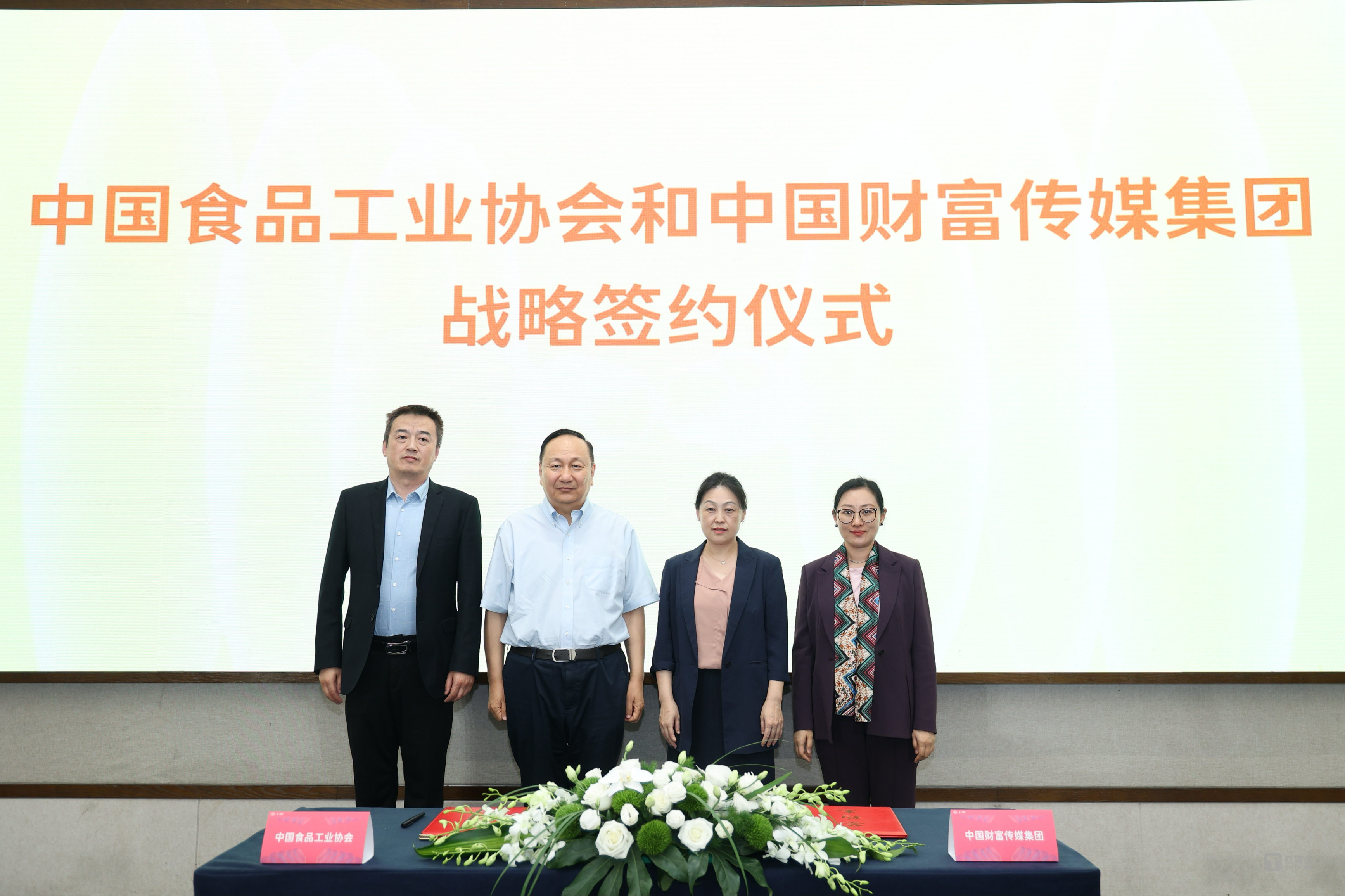 签约仪式见证嘉宾：中国食品工业协会副会长蔡永峰 （左二），中国财富传媒集团党委书记、董事长、总裁李月（右二）；签约嘉宾：中国食品工业协会副秘书长张京玉（左一），中国财富传媒集团中国财富网副总裁孙亚琼（右一）。