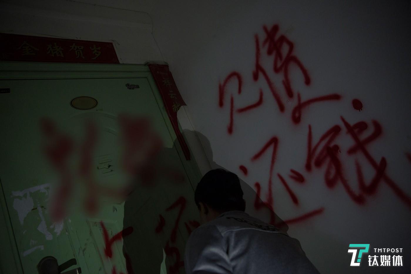 欠债还钱。广西，一名职业催债人在老赖家门上喷字。