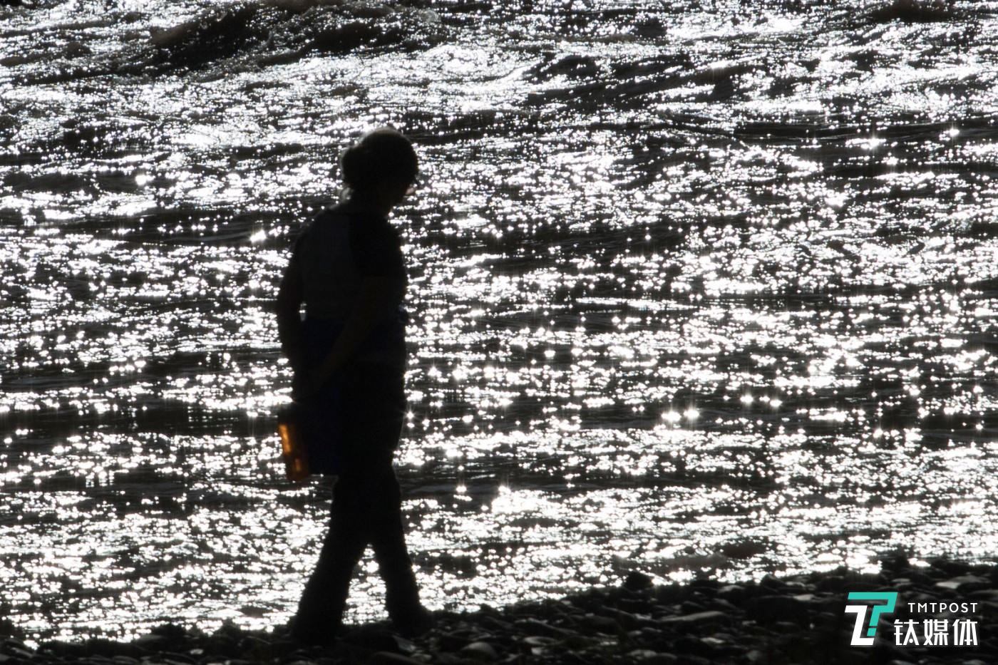 粼波微步。青海玉树杂多县，游客在澜沧江边散步。