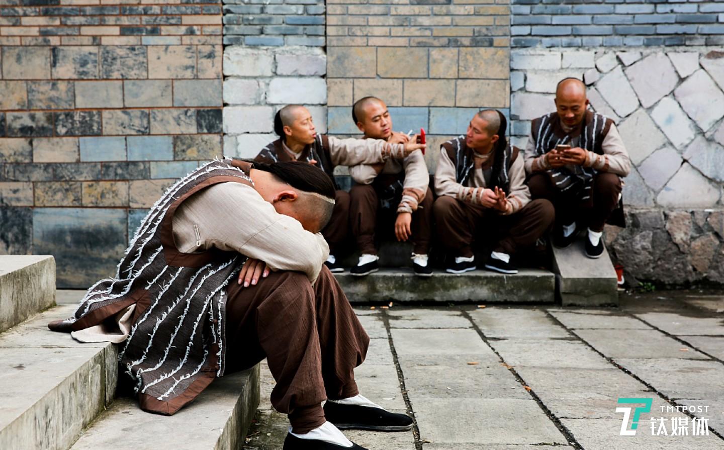 （&ldquo;寒流&rdquo;中的横店没有戏拍。图为2018年10月11日，在片场小憩的群演。根据横店演员工会最新的工资调整，普通群演每天出工10小时，可以拿到90块钱，超时1小时加10块。有时候为了化妆，一些群众演员需要凌晨两三点起床集合。图/视觉中国）