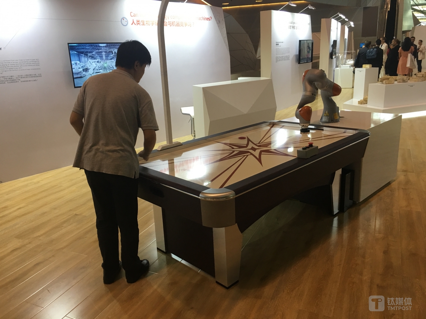 工作人员在和机器手臂对抗气悬球，后者的反应速度要比人类快十倍以上。