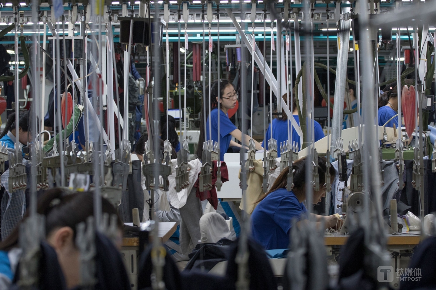 悬挂的青春。山东青岛，酷特智能车间的西服定制生产线，年轻女工在挂钩间工作。