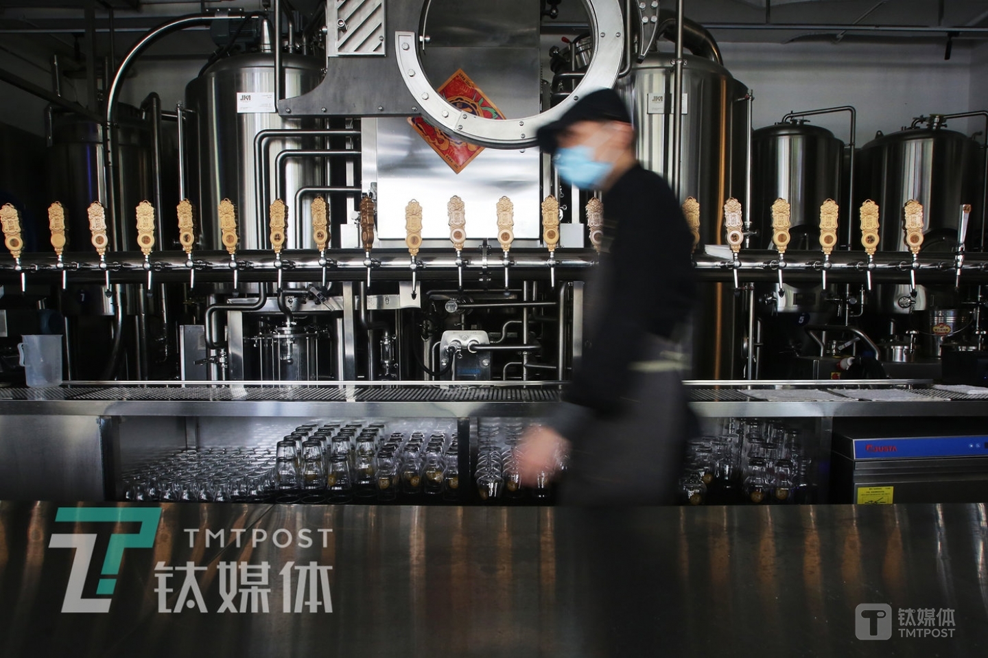 A cook passed by the counter in the pub.