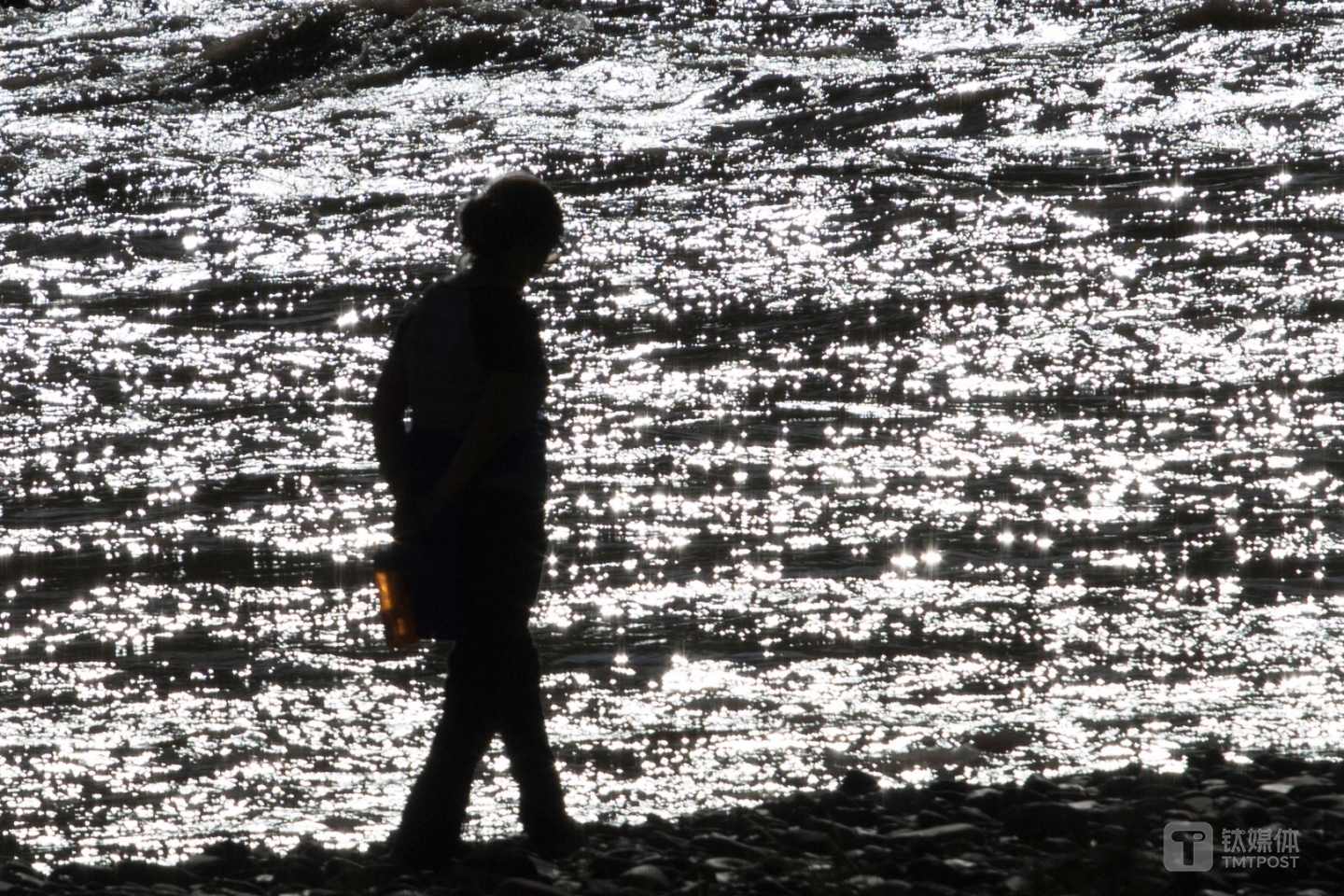 粼波微步。青海玉树杂多县，游客在澜沧江边散步。